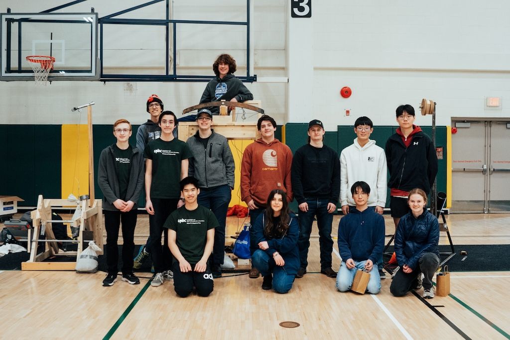 Competing teams pose together among their designed apparatuses for the 2025 High School Design Competition.