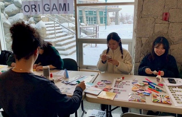 A group of students actively folding origami