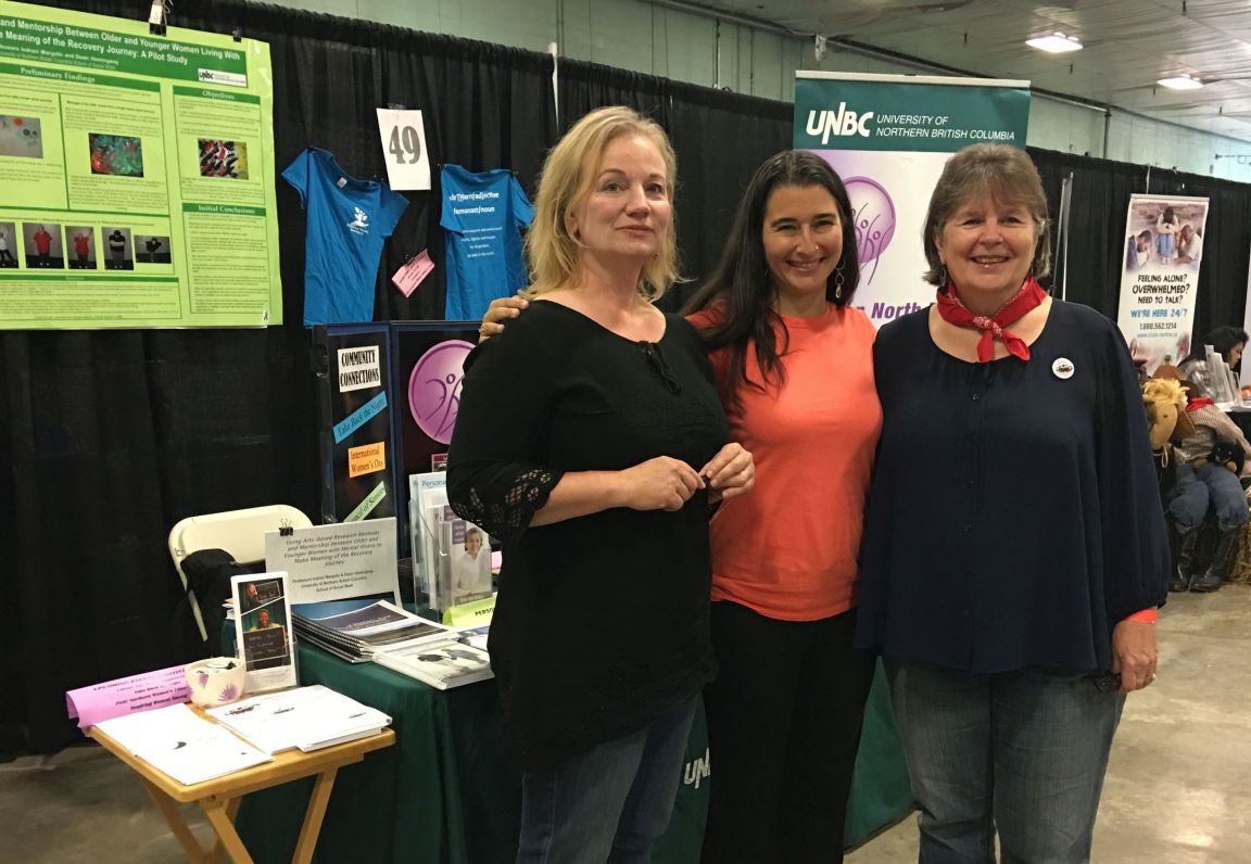 three women standing in front of northern fire research exhibit