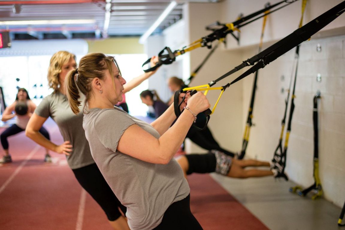 Members performing stretches on the indoor running track at the Northern Sport Centre