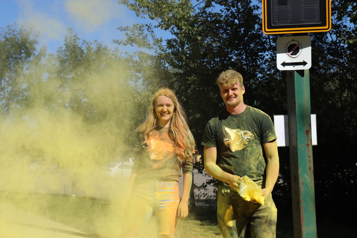 Orientation volunteers throwing coloured cornstarch