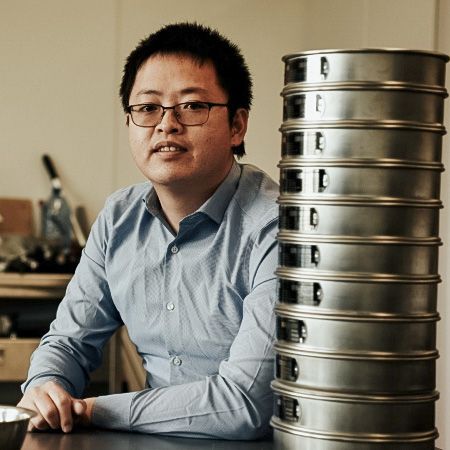 Person in a lab next to a stack of equipment