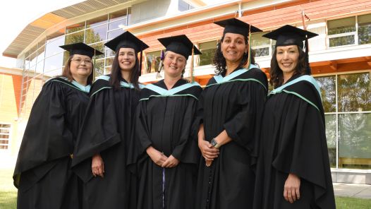 Five people in cap and gowns