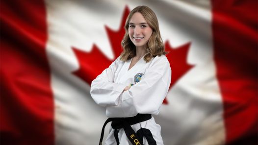 Person in a taekowndo kit standing in front of a Canadian flag
