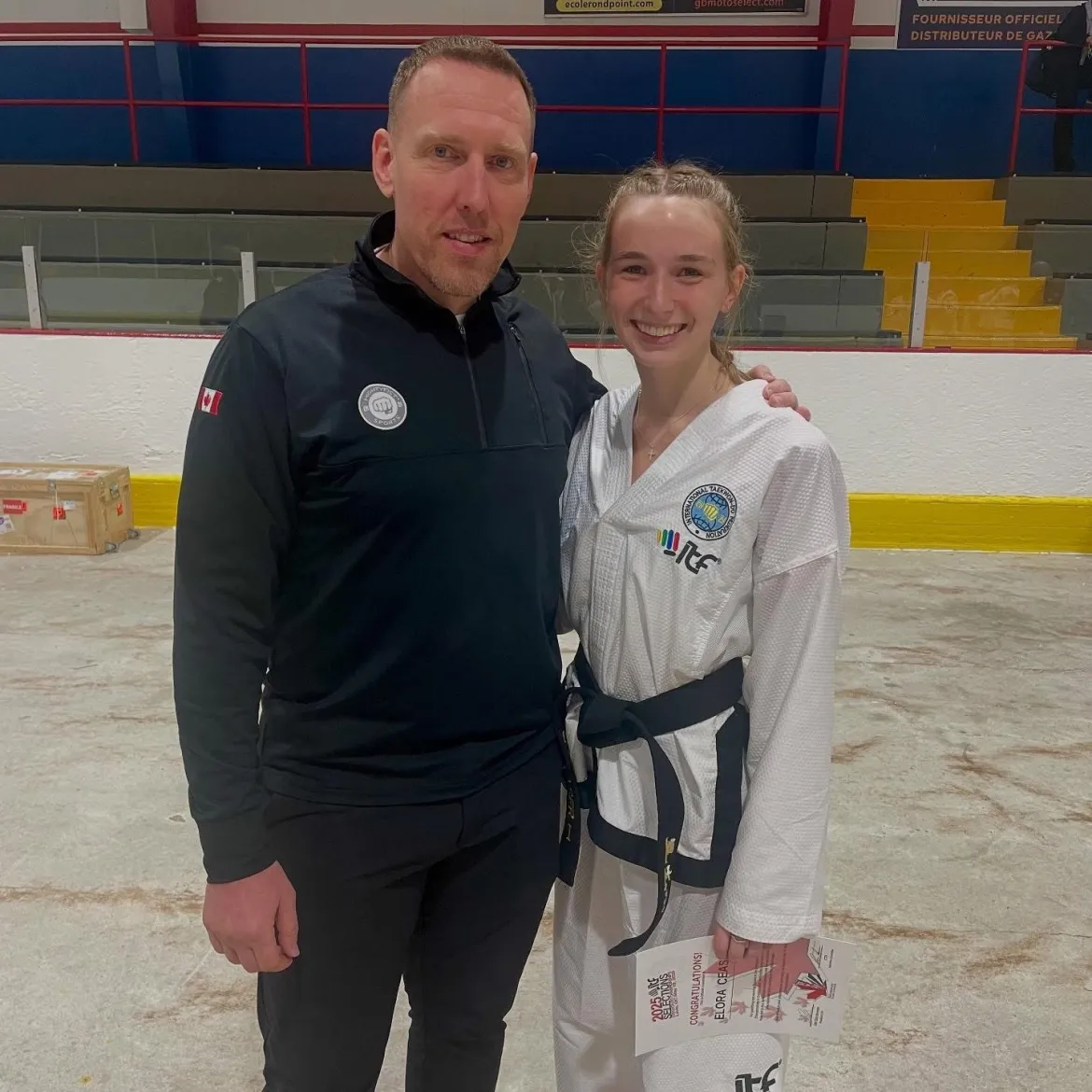 Two people in tawkwondo kits in an arena