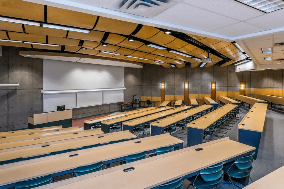 Large lecture theatre with screen on the left and rows of tiered tables on the right.