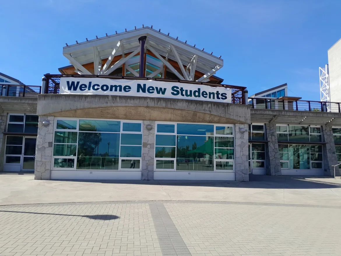 A banner with welcome new students to UNBC on a building