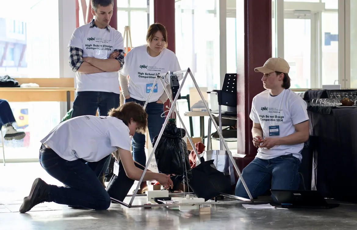 A high school student team tests and calibrates their designed apparatus during a competition.