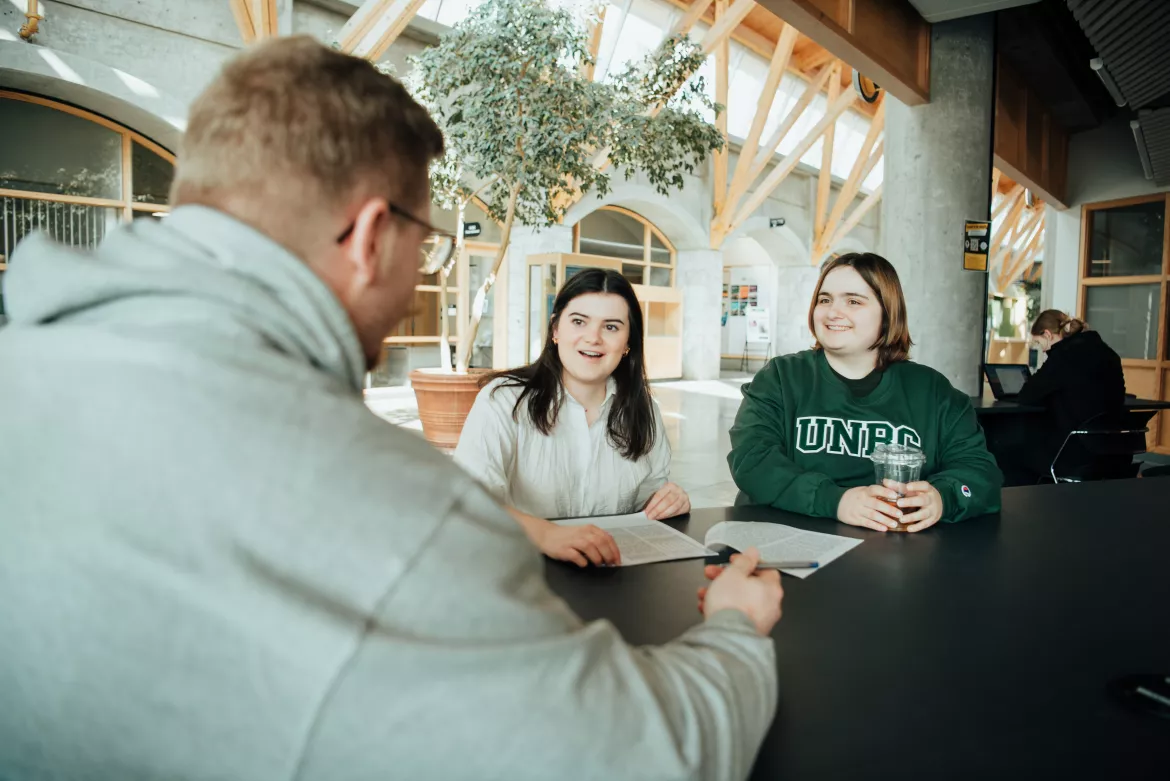UNBC Students seated discussing.