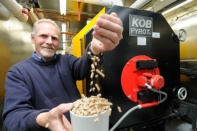 Man pouring wood pellets into a small container
