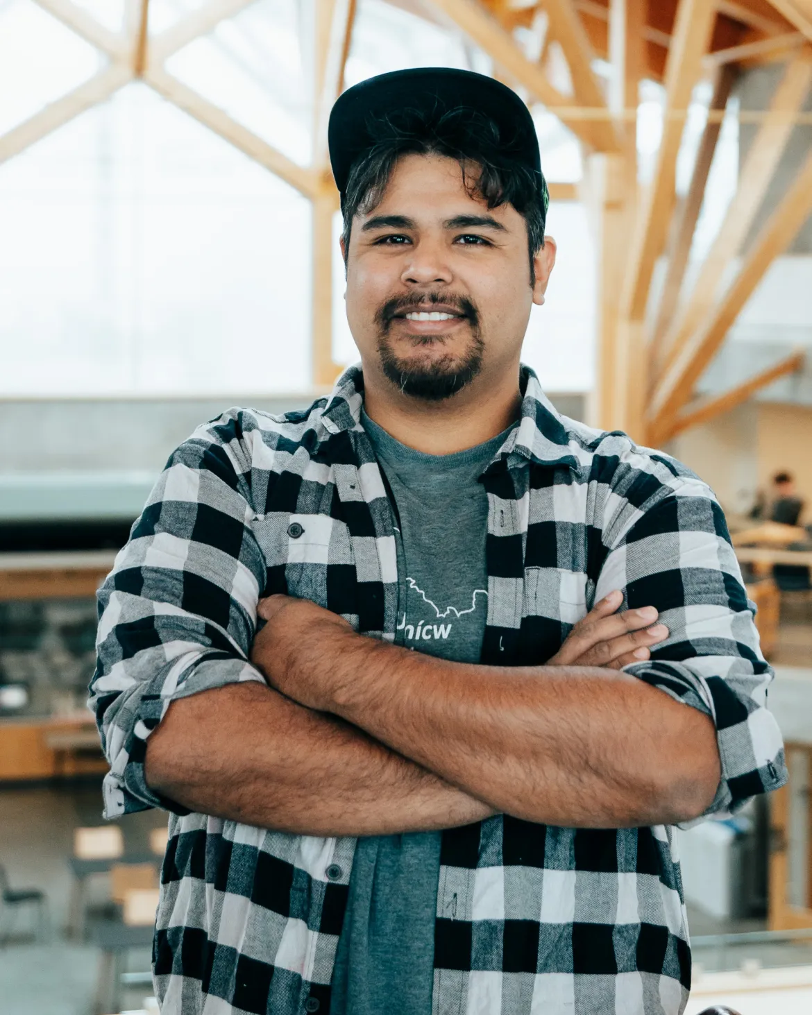 A person standing with their arms crossed at UNBC