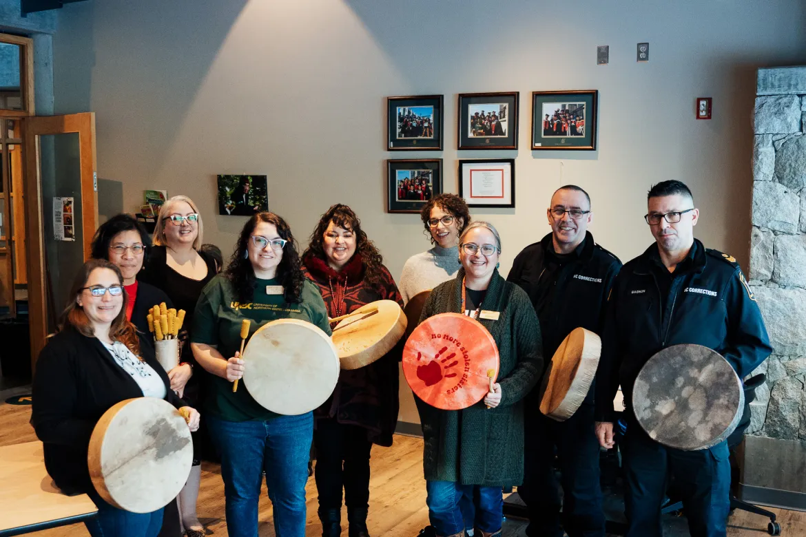 A group of people holding drums in UNBC's First Nations Centre