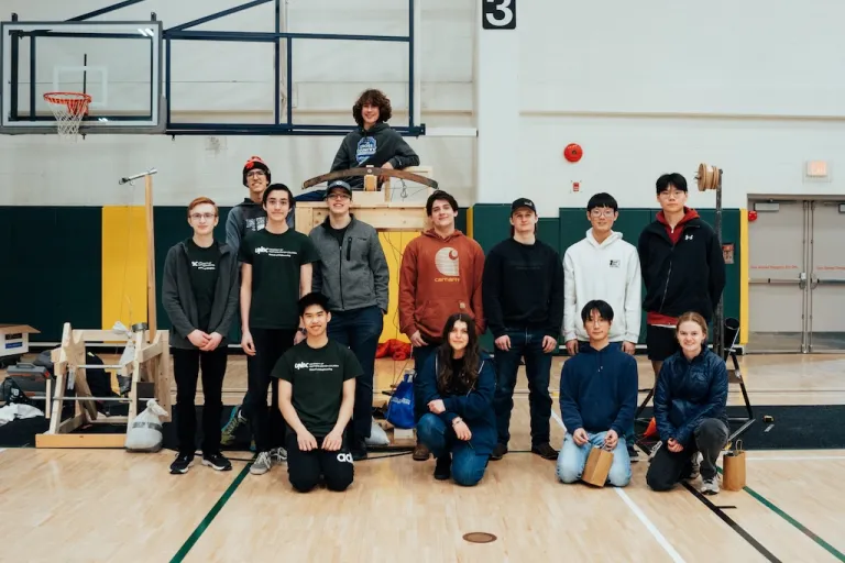Competing teams pose together among their designed apparatuses for the 2025 High School Design Competition.