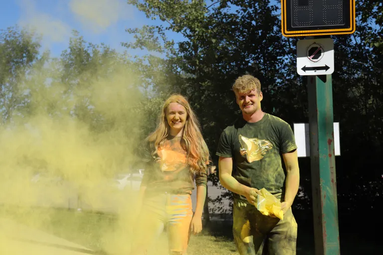 Orientation volunteers throwing coloured cornstarch