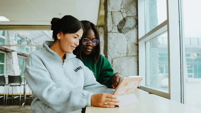 UNBC students siting at a window