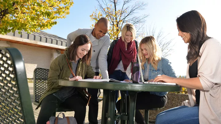 UNBC students sitting at a table outdoors