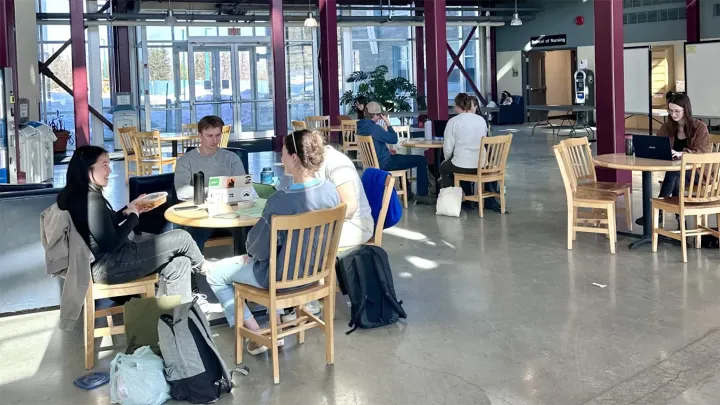 Students sitting at tables in the Teaching and Learning building