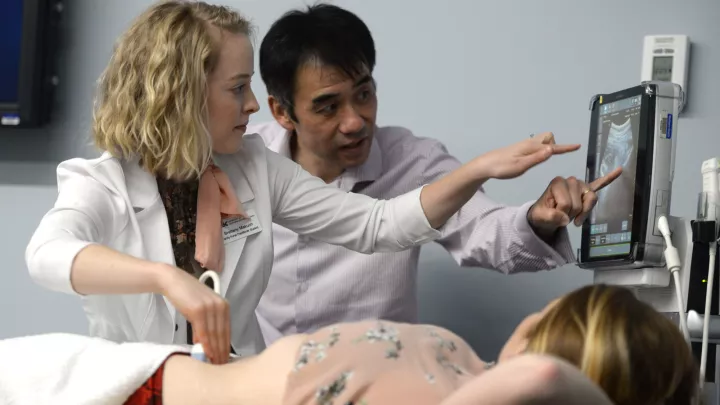 Medical student and teacher examining a screen