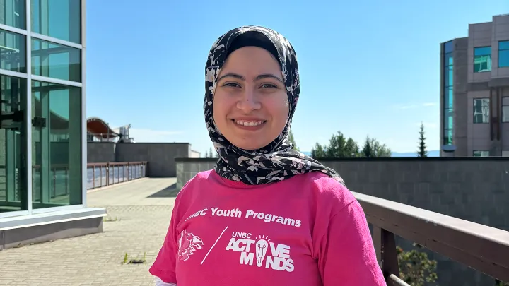 Young lady at UNBC campus wearing pink Active Minds t-shirt