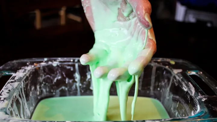 Youth playing with green slime in science experiment