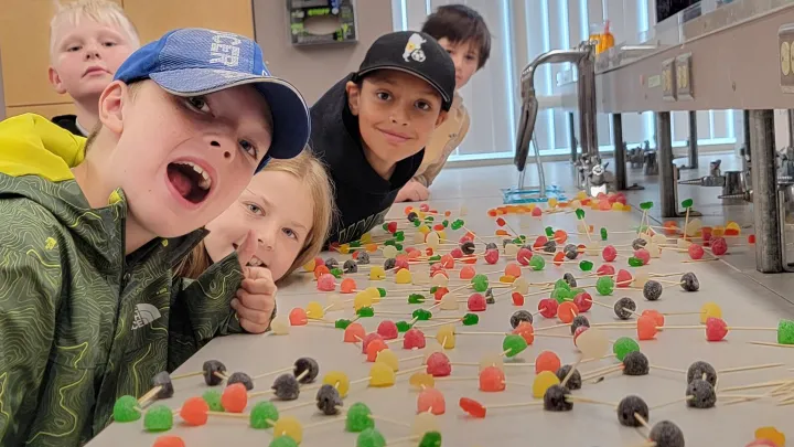 Group of children smiling with table full of candy