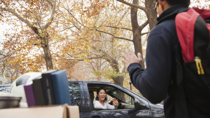 Student waving to parent leaving