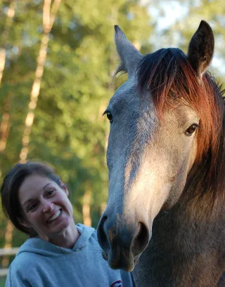 Kristen Guest standing beside a horse