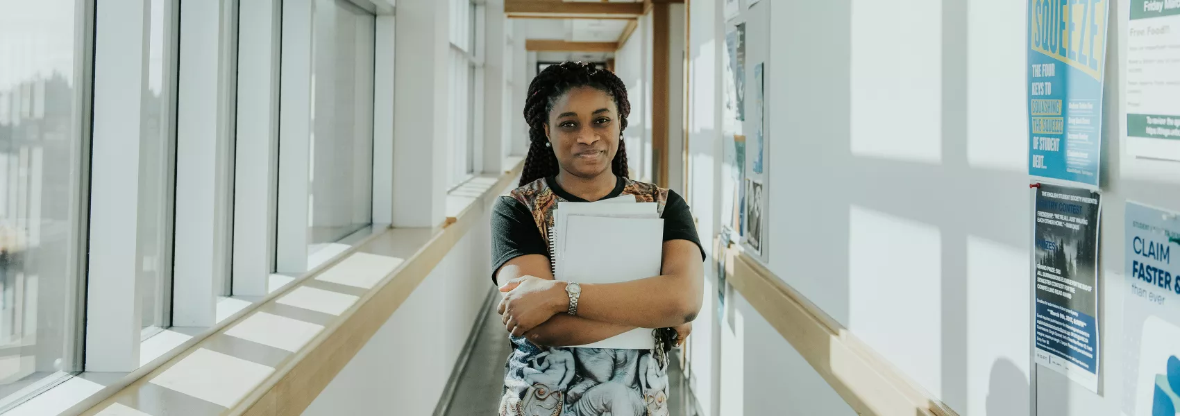 a young woman standing in the hallway of UNBC lab building