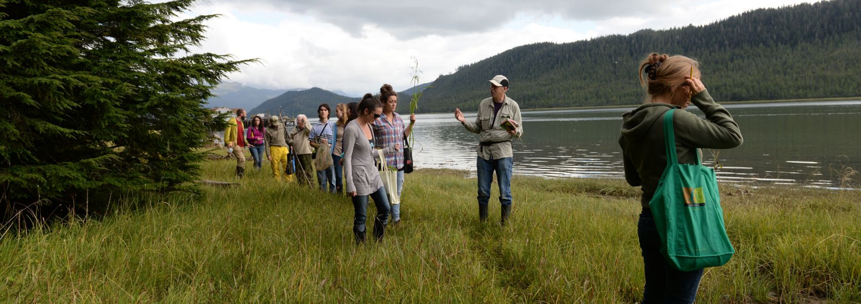 Students in the field exploring near a lake