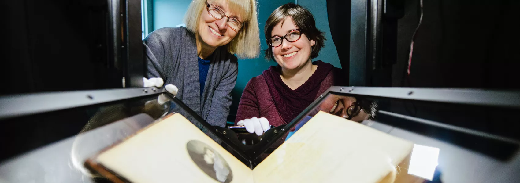 Two people reviewing historical slides