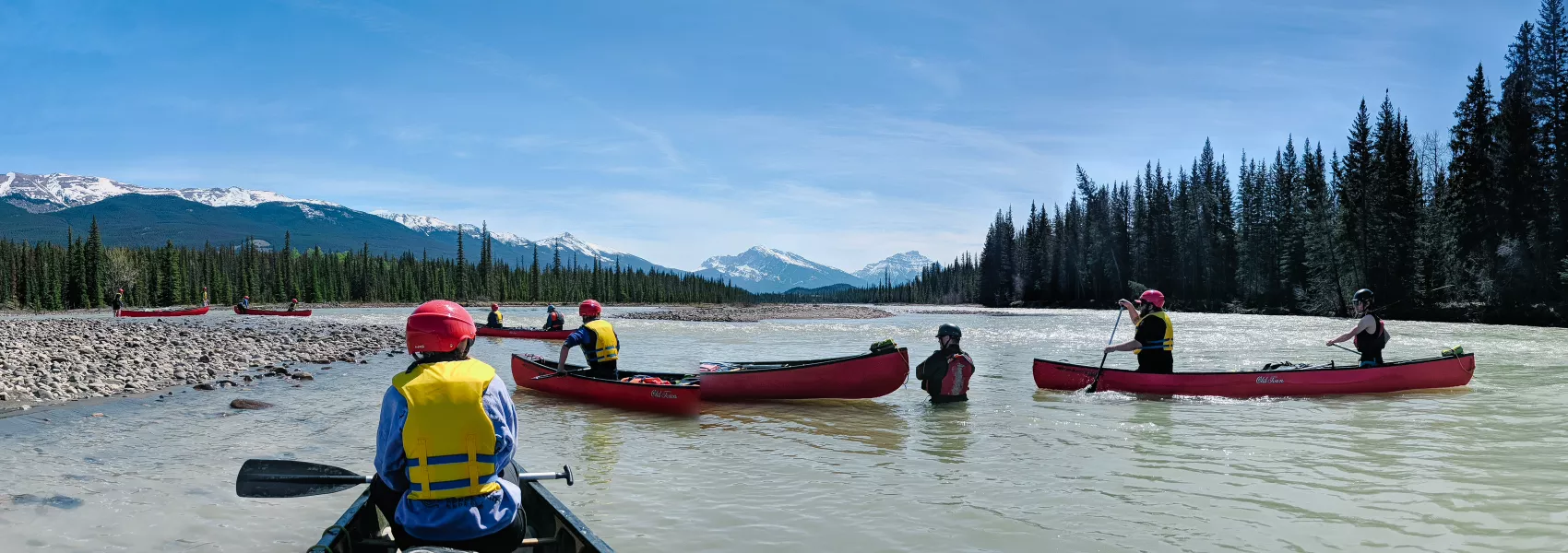 Multiple students in canoes on the water
