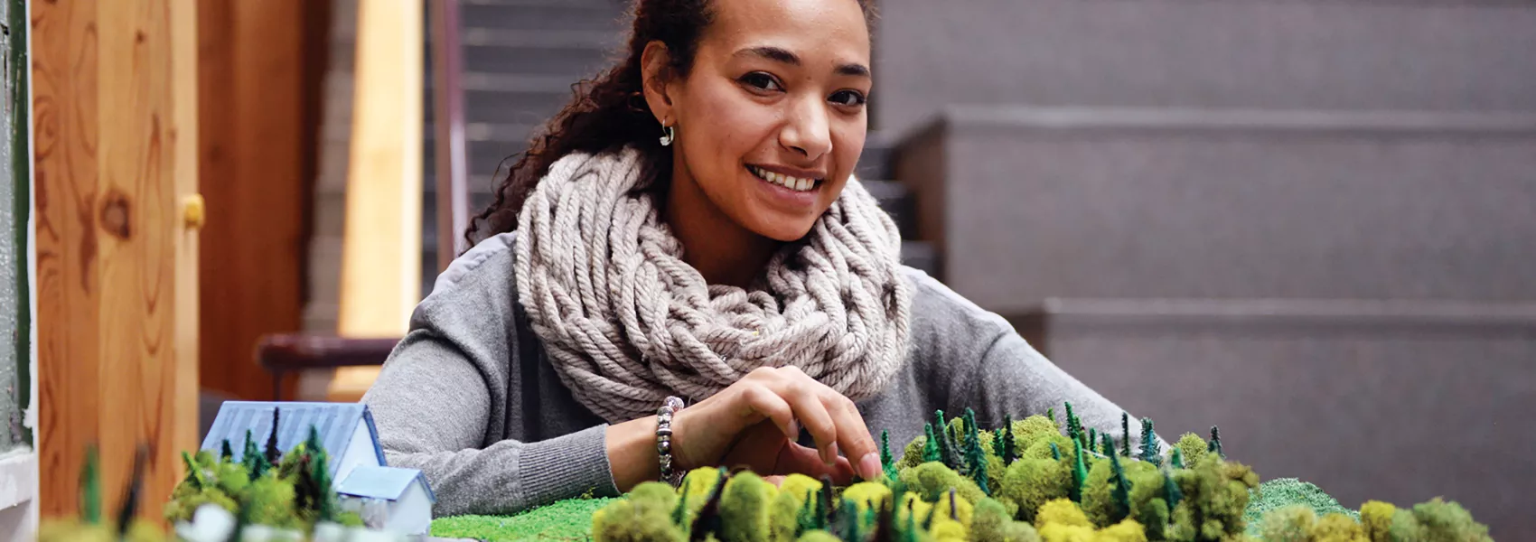 Woman behind diorama of a northern community at UNBC