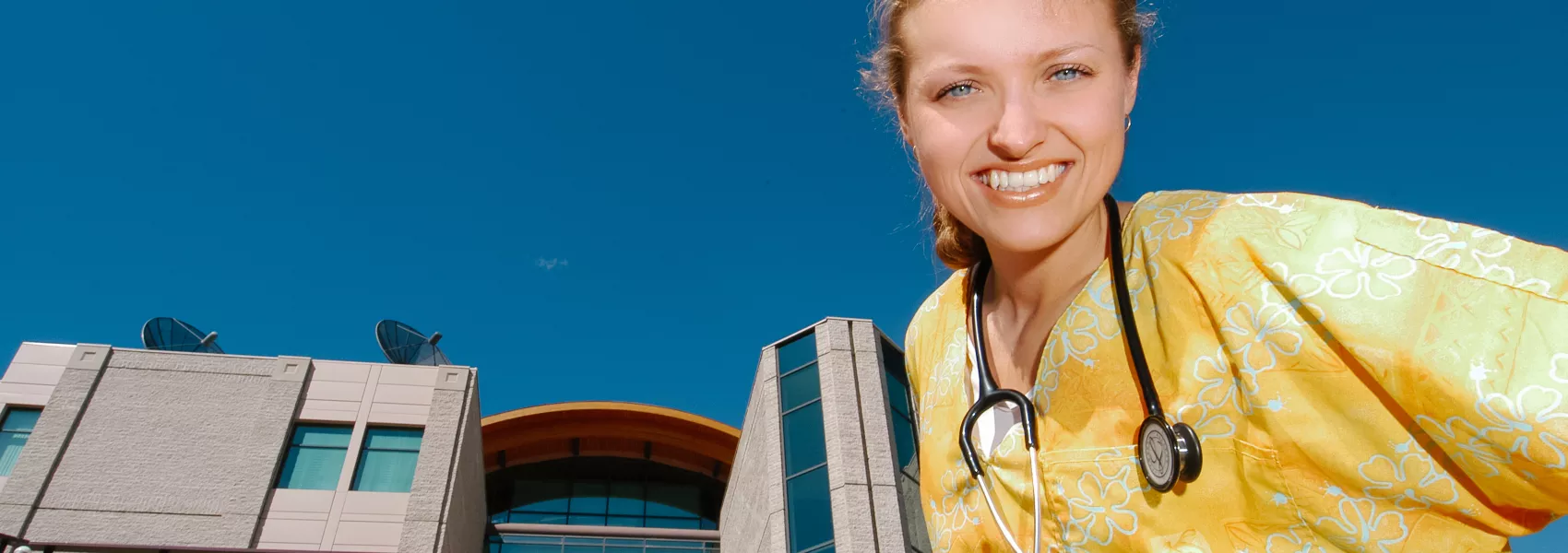 Nursing student standing in front of a UNBC building