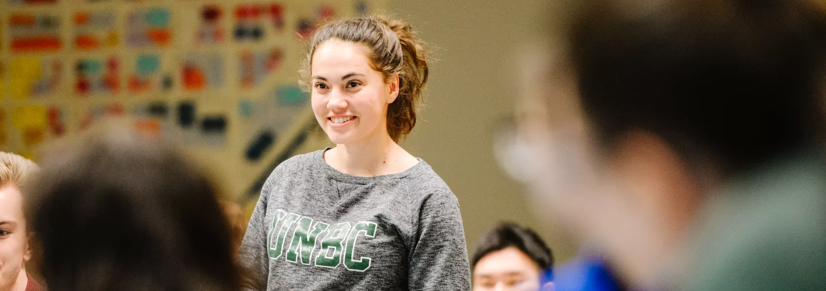 Smiling female student in the classroom with peers